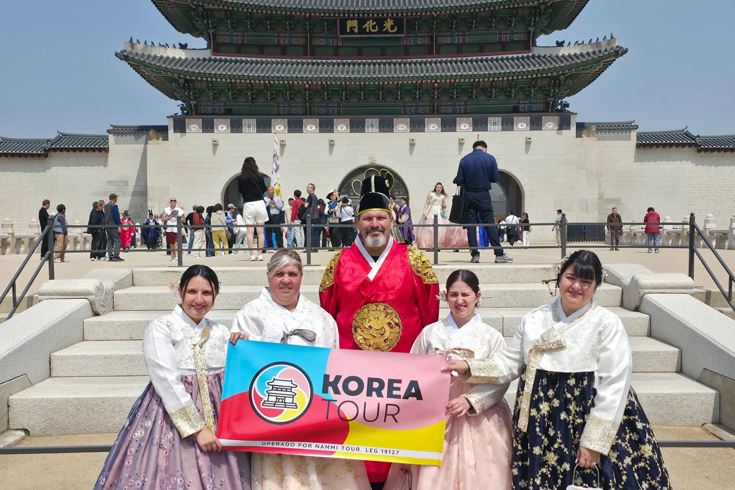 Grupo de Korea Tour vestido de hanbok frente a la puerta Gwanghwamun, palacio Gyeongbokgung, Seúl.